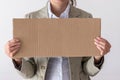 A woman holds blank sign in front her face