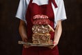 Woman holds board in hand with boiled pork meat roll, beef tongue roll and homemade sausage Royalty Free Stock Photo