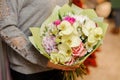 Woman holds a bouquet with beige orchids, pink roses and purple hydrangea Royalty Free Stock Photo