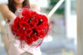 woman holds bouquet of red roses in her hand after receiving one from her boyfriend on Valentine Day to show his love for woman