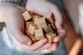 Woman holds brown sugar cubes in hands. Royalty Free Stock Photo