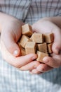 Woman holds brown sugar cubes in hands. Royalty Free Stock Photo