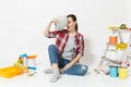 Woman holds bundle of dollars, cash money, sits on floor with instruments for renovation apartment isolated on white Royalty Free Stock Photo