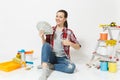 Woman holds bundle of dollars, cash money, sits on floor with instruments for renovation apartment isolated on white Royalty Free Stock Photo