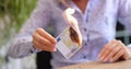 Woman holds burning two hundred Eurozone banknote