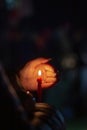 A woman holds a candle in her hand, covering the flame from the wind with her palm, in memory of the dead, killed, dead Royalty Free Stock Photo
