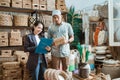 woman holds the clipboard and the man holds the wicker box while checking items Royalty Free Stock Photo