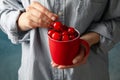 Woman holds cup with fresh red cherry close up Royalty Free Stock Photo