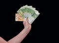 Woman holds euro cash in his hand on black background Royalty Free Stock Photo