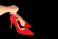 Woman holds fashionable red shoes in her hand. Royalty Free Stock Photo