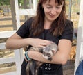 A woman holds a ferret in her arms