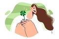 Woman holds four-leaf clover petal and rejoices at approaching holiday of St. Patrick day