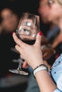 Woman holds glass of red wine. people consider the color of the wine and try how it smells in different glasses