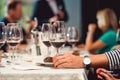 Woman holds glass of red wine. people consider the color of the wine and try how it smells in different glasses