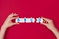 Woman holds in hand a jigsaw puzzle with A, B, C, D letters isolated on red or magenta background. Educational concept