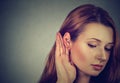 Woman holds hand near ear and listens carefully Royalty Free Stock Photo