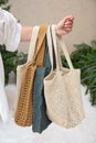 Woman holds a handmade many knitted bags outdoors. Sustainable shopping. Wasteless lifestyle Royalty Free Stock Photo