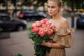 Woman holds in her hand bouquet of stylish bright peony roses