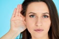 Woman holds her hand near ear and listens carefully Royalty Free Stock Photo