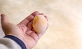 A woman holds in her hands an egg without shell, which gave sick chicken