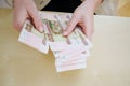 a woman holds in her hands and recalculates Russian banknotes of 100 rubles. Royalty Free Stock Photo