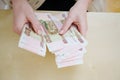 a woman holds in her hands and recalculates Russian banknotes of 100 rubles. Royalty Free Stock Photo