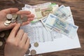 A woman holds in her hands Russian money, a piece of paper with numbers on top of a receipt for payment of utilities. Background Royalty Free Stock Photo