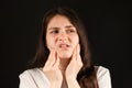 A woman holds her hands to a sore temporomandibular joint, dysfunction and pain, dislocated jaw, problems of wisdom