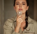 Woman holds incandescent light bulb in front of her