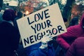 Woman Holds Love Your Neighbor Sign at Rally after the Election of Donald Trump