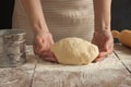 A woman holds a dough in her hands