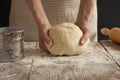 A woman holds a dough in her hands