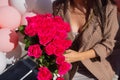 Woman holds luxury bouquet of red roses.