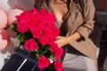 Woman holds luxury bouquet of red roses.