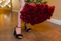 Woman holds luxury bouquet of red roses.