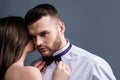 Woman holds mans bowtie, bow tie. Sexy couple in love. Sensual lovers undressed. Girlfriend and boyfriend sensual