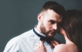 Woman holds mans bowtie, bow tie. Sexy couple in love. Sensual lovers undressed. Girlfriend and boyfriend sensual