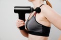 Woman holds a massage gun. medical-sports device