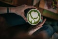 Woman holds matcha tea latte in cup Royalty Free Stock Photo