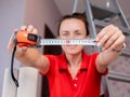 Measuring construction tape measure in the hands of a woman. Renovation of the apartment. Royalty Free Stock Photo