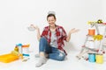 Woman holds metal grocery baskets for shopping, sits on floor with instruments for renovation apartment isolated on Royalty Free Stock Photo