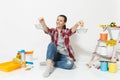 Woman holds metal grocery baskets for shopping, sits on floor with instruments for renovation apartment isolated on Royalty Free Stock Photo