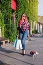 Fashionably dressed girl at the window of a boutique selling clothes. A woman holds a mini chihuahua in her arms. The pet is Royalty Free Stock Photo