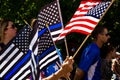 A Woman Waves Thin Blue Line and American Flags at a Conservative Rally