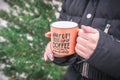 Woman holds a orange coffee cup. Hot winter drink in hands. Royalty Free Stock Photo