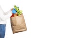 Woman holds a paper bag filled with groceries such as fruits, vegetables, milk, yogurt, eggs isolated on white