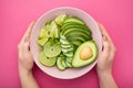 a woman holds a plate with a dietal avocado salad Royalty Free Stock Photo