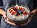 A woman holds a plate of rice porridge and fresh figs in her hands. Generated by AI