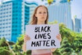 Woman holds a poster with an inscription - black lives matter