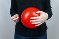 Conceptual photography. The woman holds a red ball near his belly, which symbolizes bloating and flatulence. Then she brings a nee